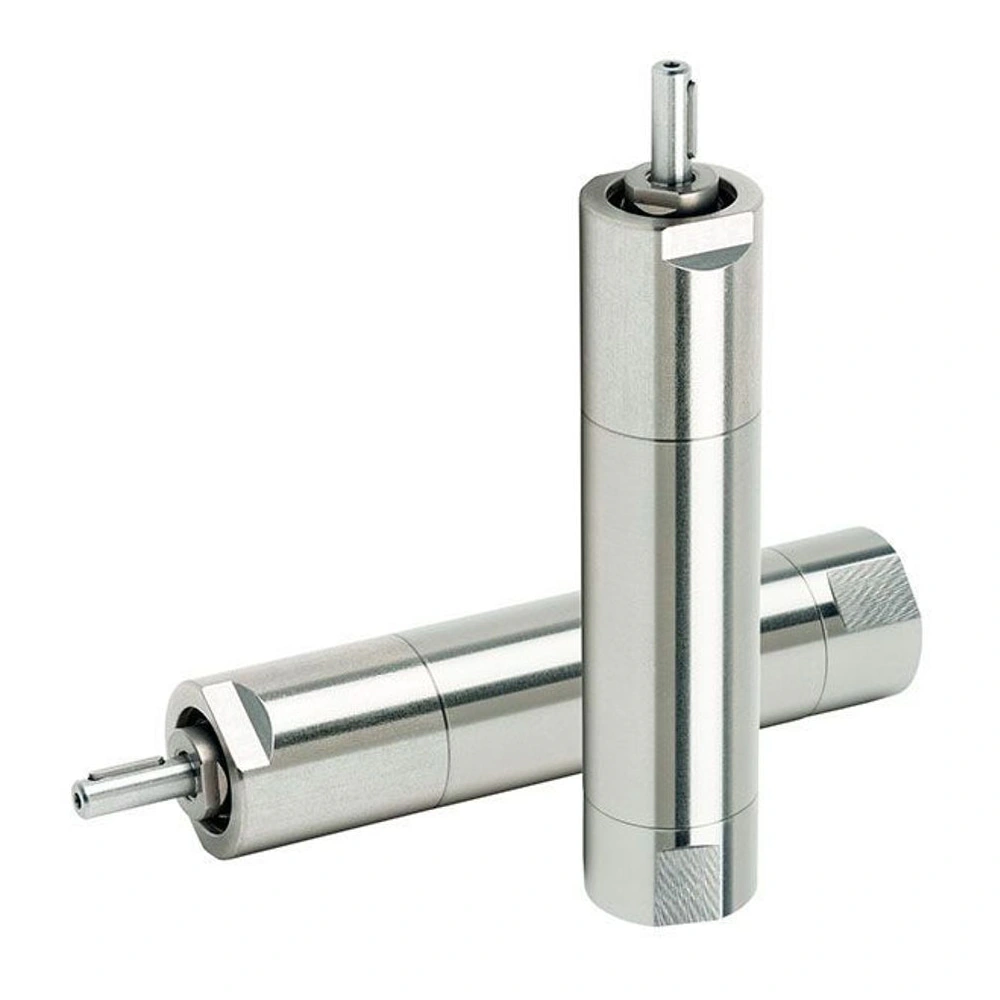 Two silver metal cylindrical motors, one standing vertically and one lying