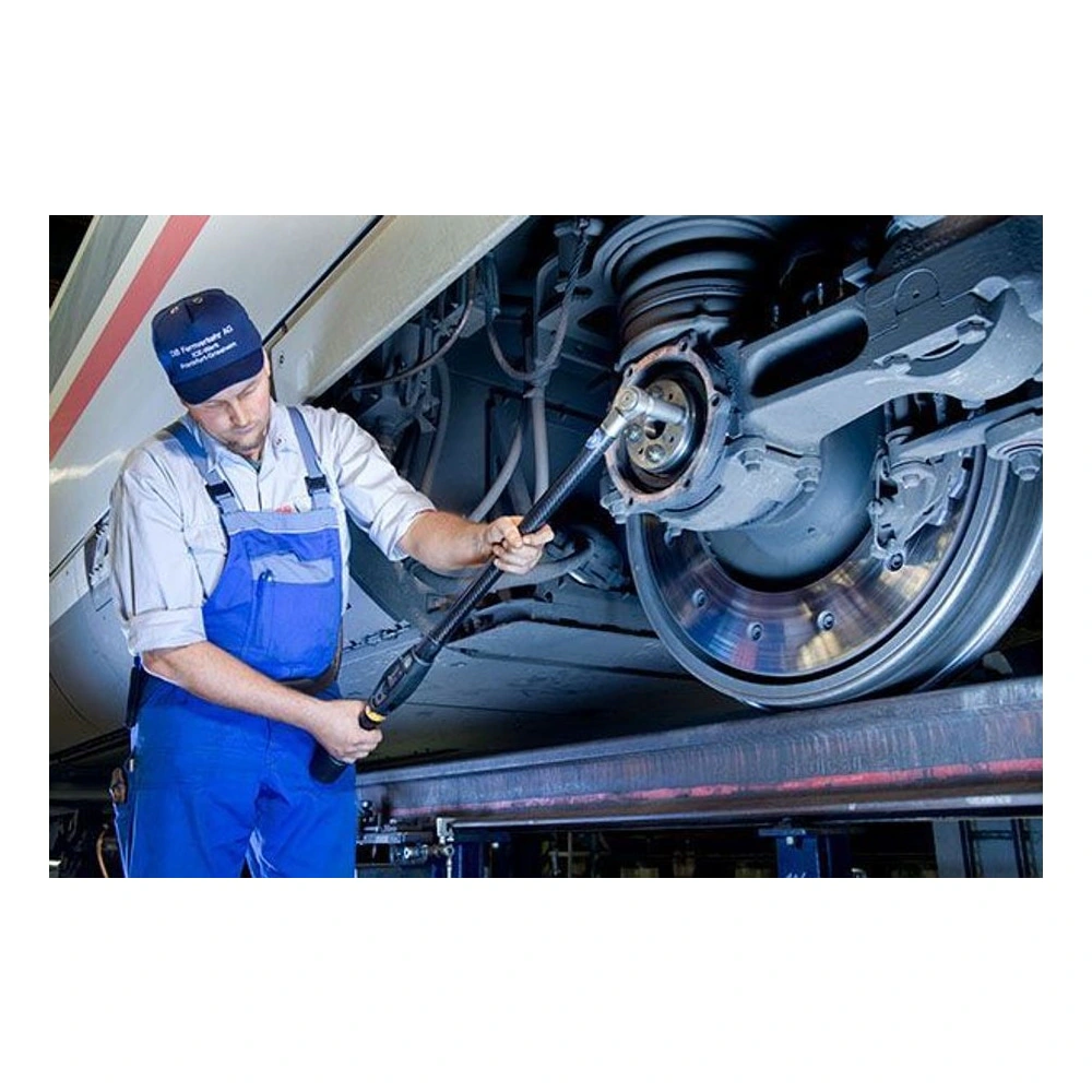 A technician with a long digital torque wrench works on a wheel or axle