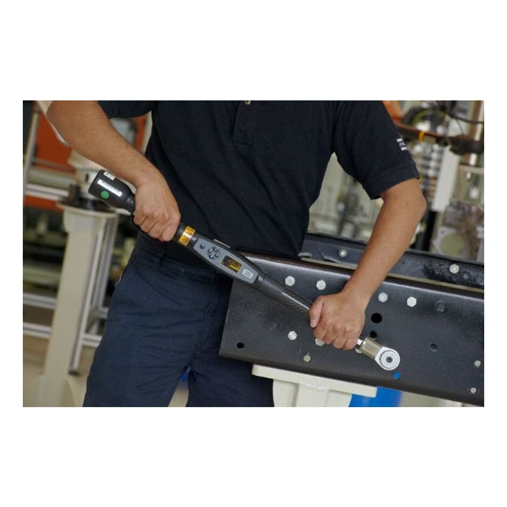 A person holds a digital torque wrench and uses it on a perforated metal