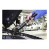 A long digital torque wrench is being used near an open engine bay