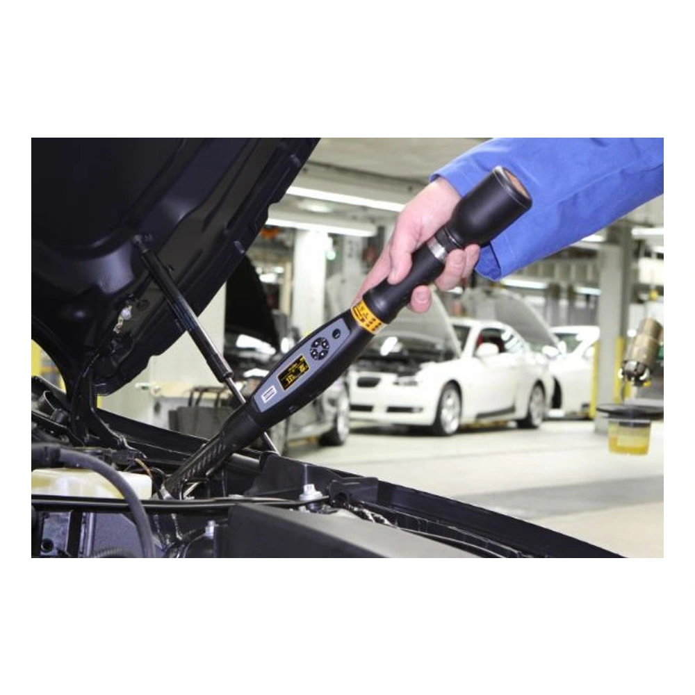 A long digital torque wrench is being used near an open engine bay