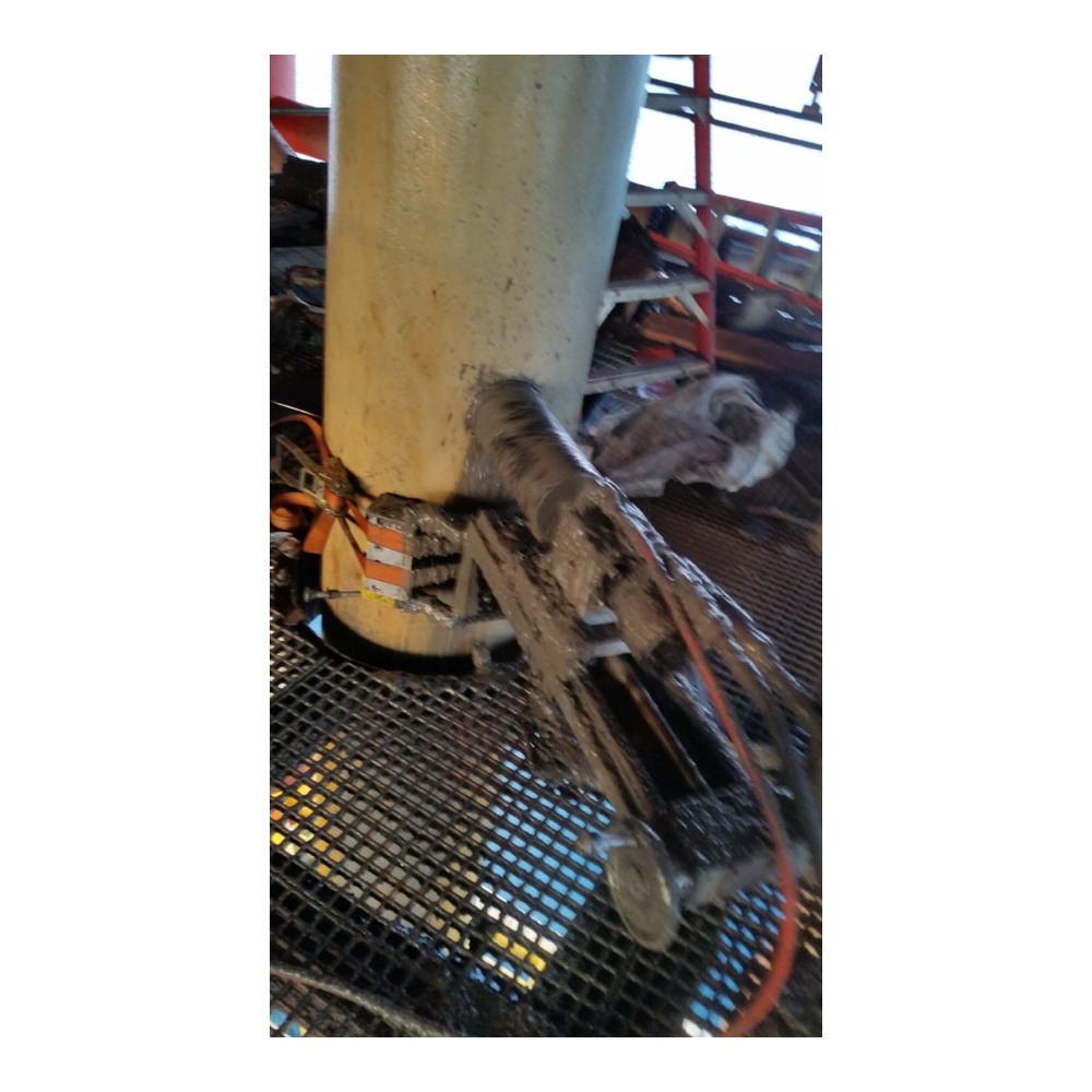 מקדחה תעשייתית וצינורות מחוברים לצינור אנכי באתר עבודה - Industrial drill and hoses attached to vertical pipe at a worksite