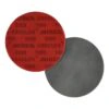Two overlapping round discs, one red with printed text and one dark gray