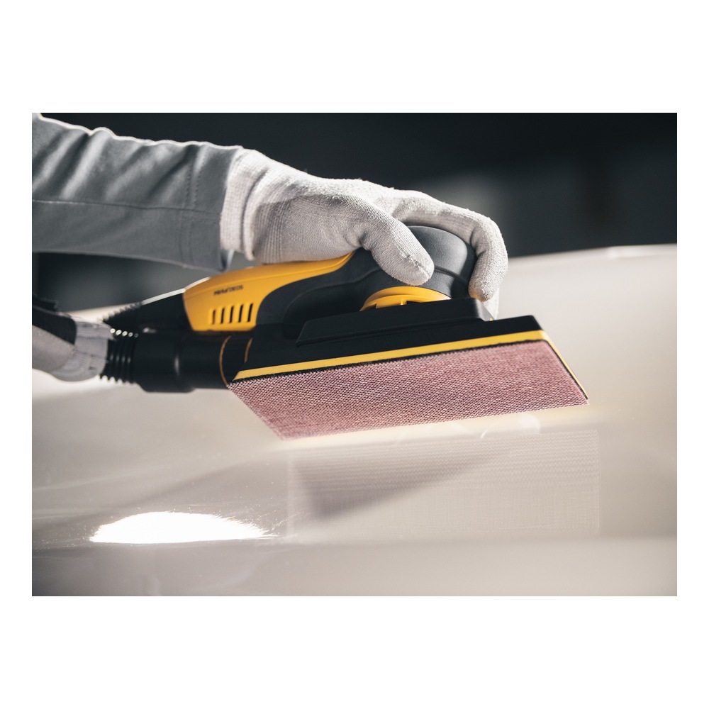 Close-up of a yellow and black hand sander with a mesh pad, held by a gloved