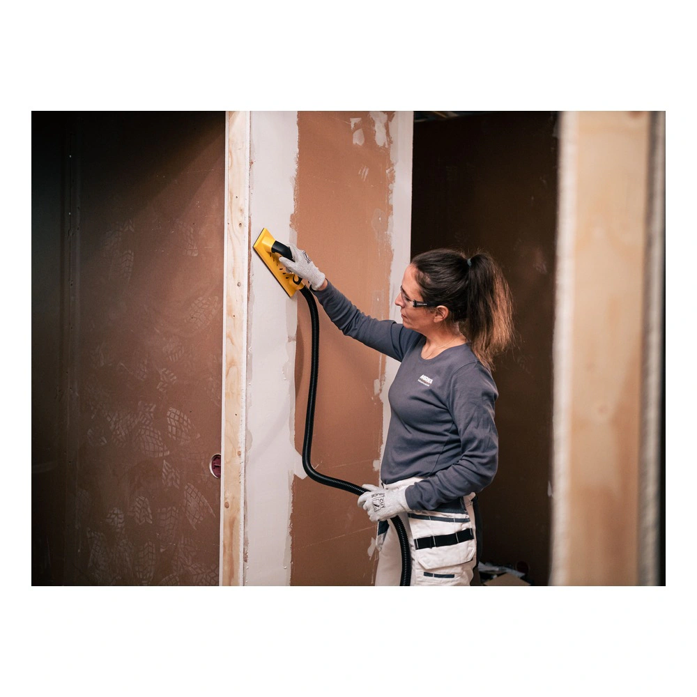 An application scene of a person sanding a wall inside a construction space