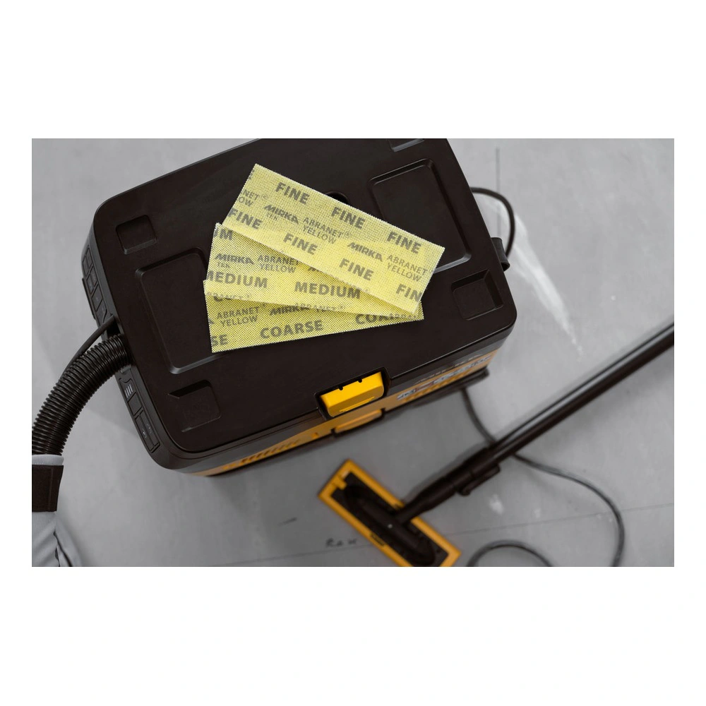 A black dust extractor with yellow sanding sheets placed on top
