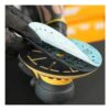 A gloved hand holds a round sanding pad with several layered perforated