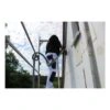 A person working on an exterior wall using a sanding tool, on scaffolding