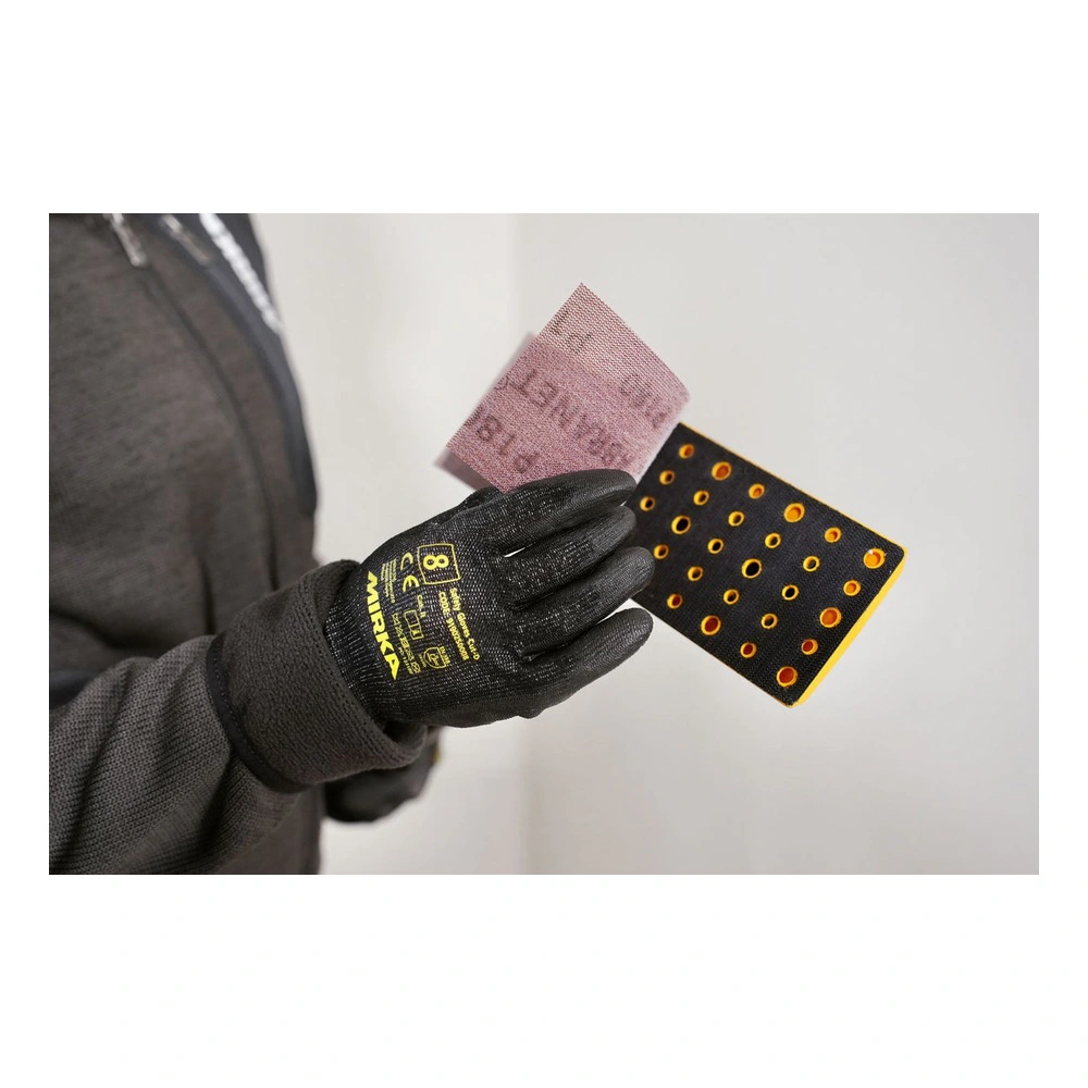 Close-up of a gloved hand holding a sanding sheet and a perforated
