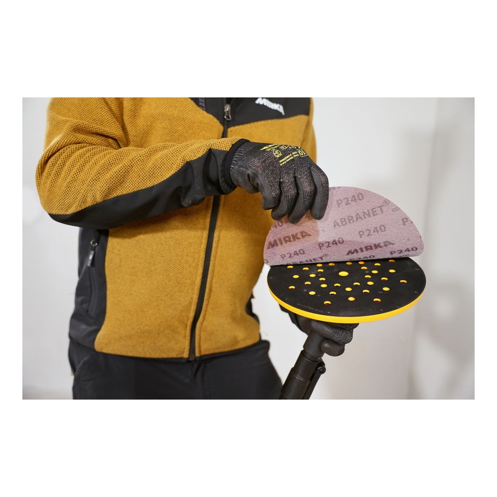 A person is holding a perforated half-round sanding pad