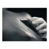 Close-up of a gloved hand holding sanding paper against a black surface