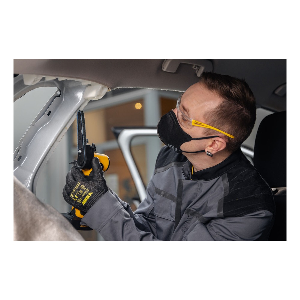 A person works inside a car interior with a yellow and black cordless file