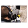 A person uses a yellow and black cordless file belt sander on a metal area