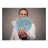 A person is holding three blue sanding discs with holes and printed text