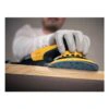 Yellow hand sander on a wooden surface