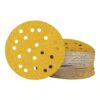 A stack of perforated round yellow sanding discs, with one disc placed