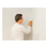 Person sanding a wall with yellow paper