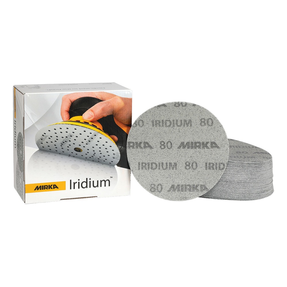 Open product box beside a stack of round sanding discs, with one disc placed