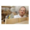 A person is holding a perforated sanding disc against a wooden surface