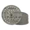 A stack of gray round sanding discs with holes, with one disc shown in front