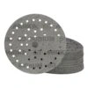 Two overlapping perforated sanding discs, with a stack of additional discs