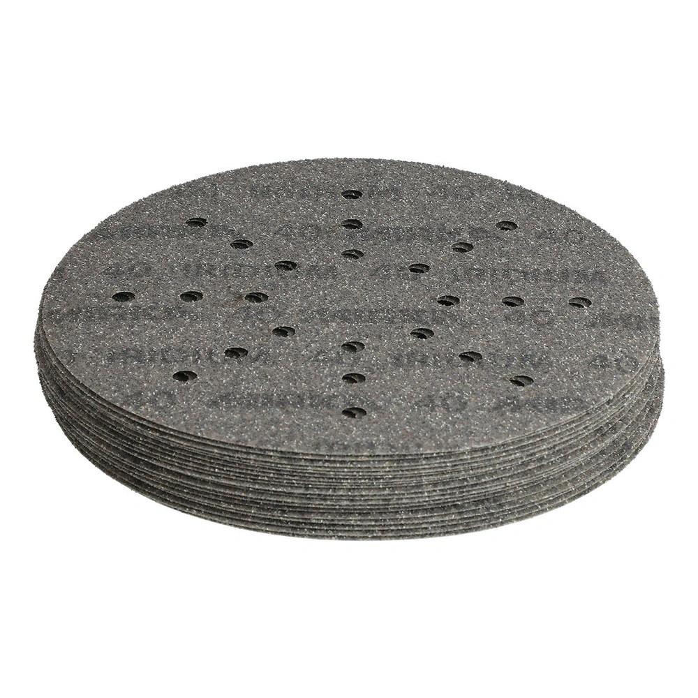 A stack of dark round sanding discs seen at an angle, with visible dust