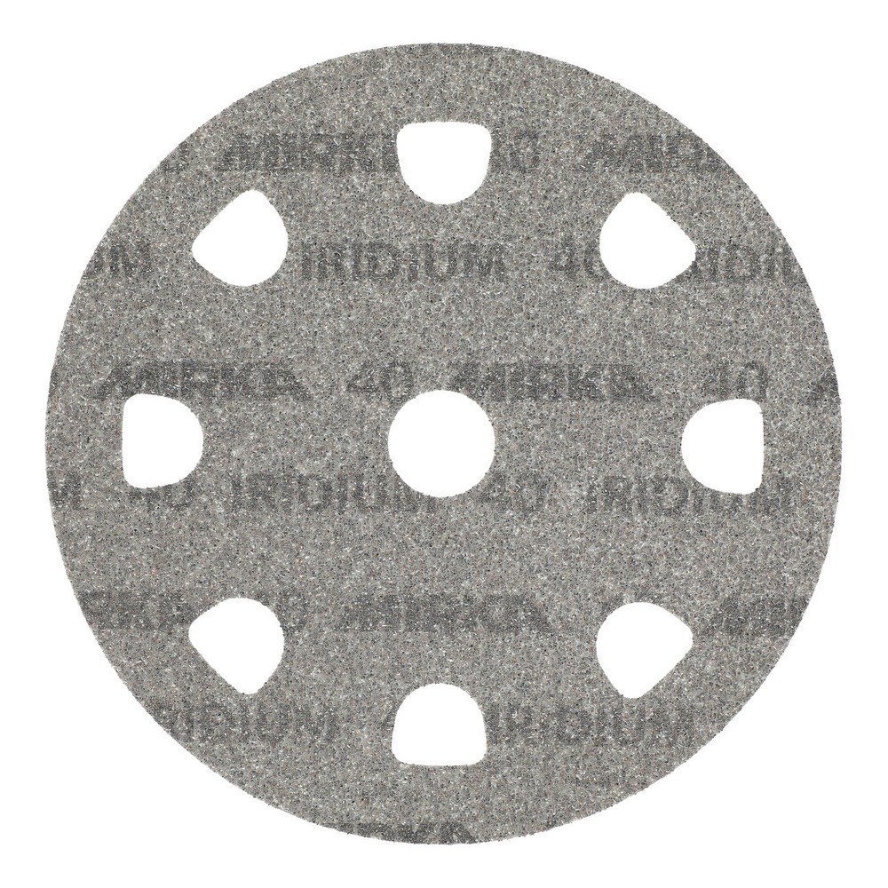 A gray round sanding disc with large arched holes and a center hole, seen