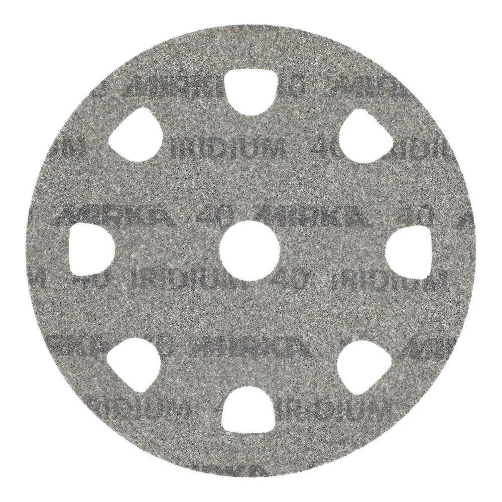 A gray round sanding disc with large arched holes and a center hole, seen
