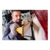 Person using a hand sander on red surface
