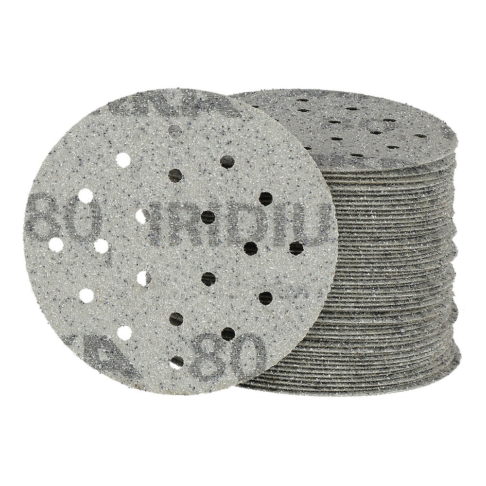 Stack of perforated circular sanding discs, with one disc placed in front