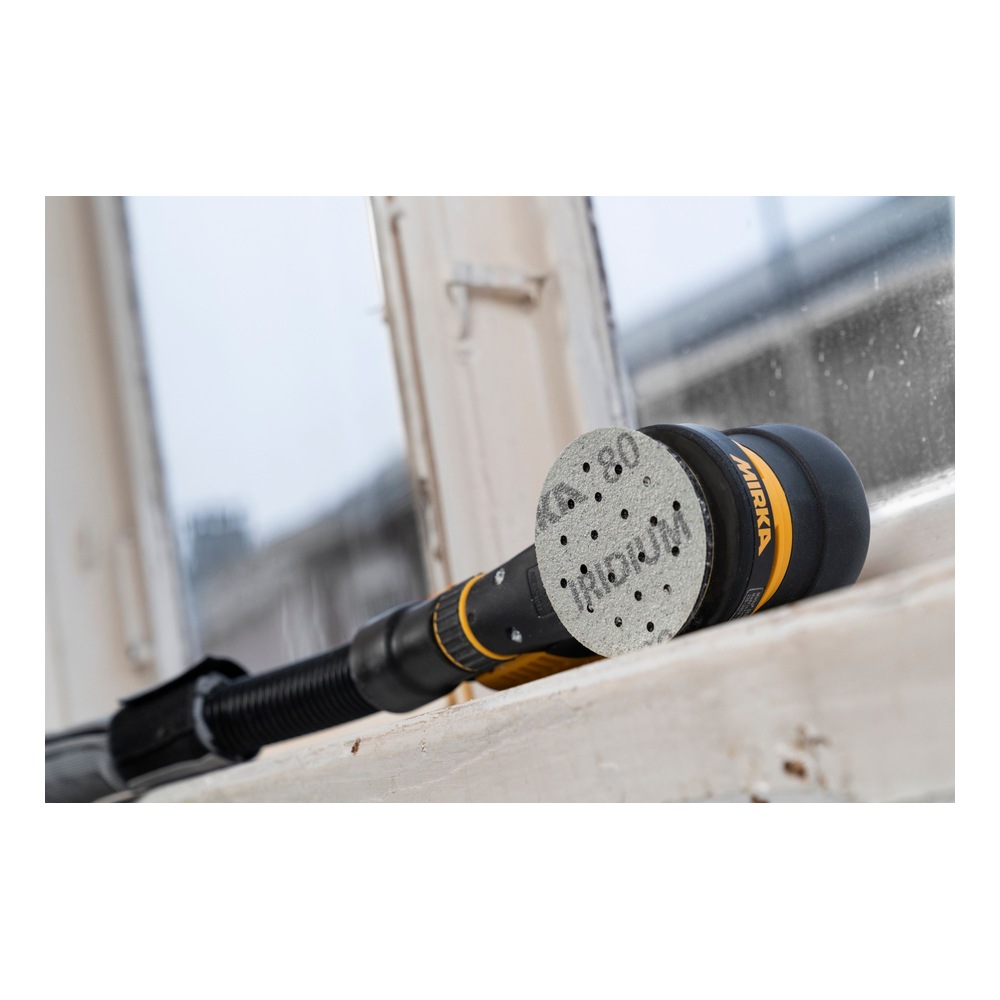 A black-and-yellow hand sander with a gray perforated sanding disc is shown