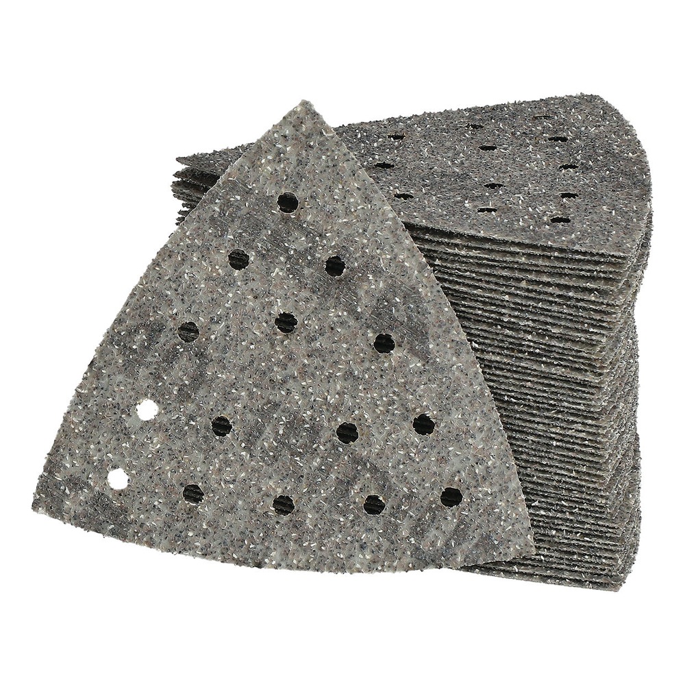 A stack of perforated triangular sanding sheets, with one sheet placed