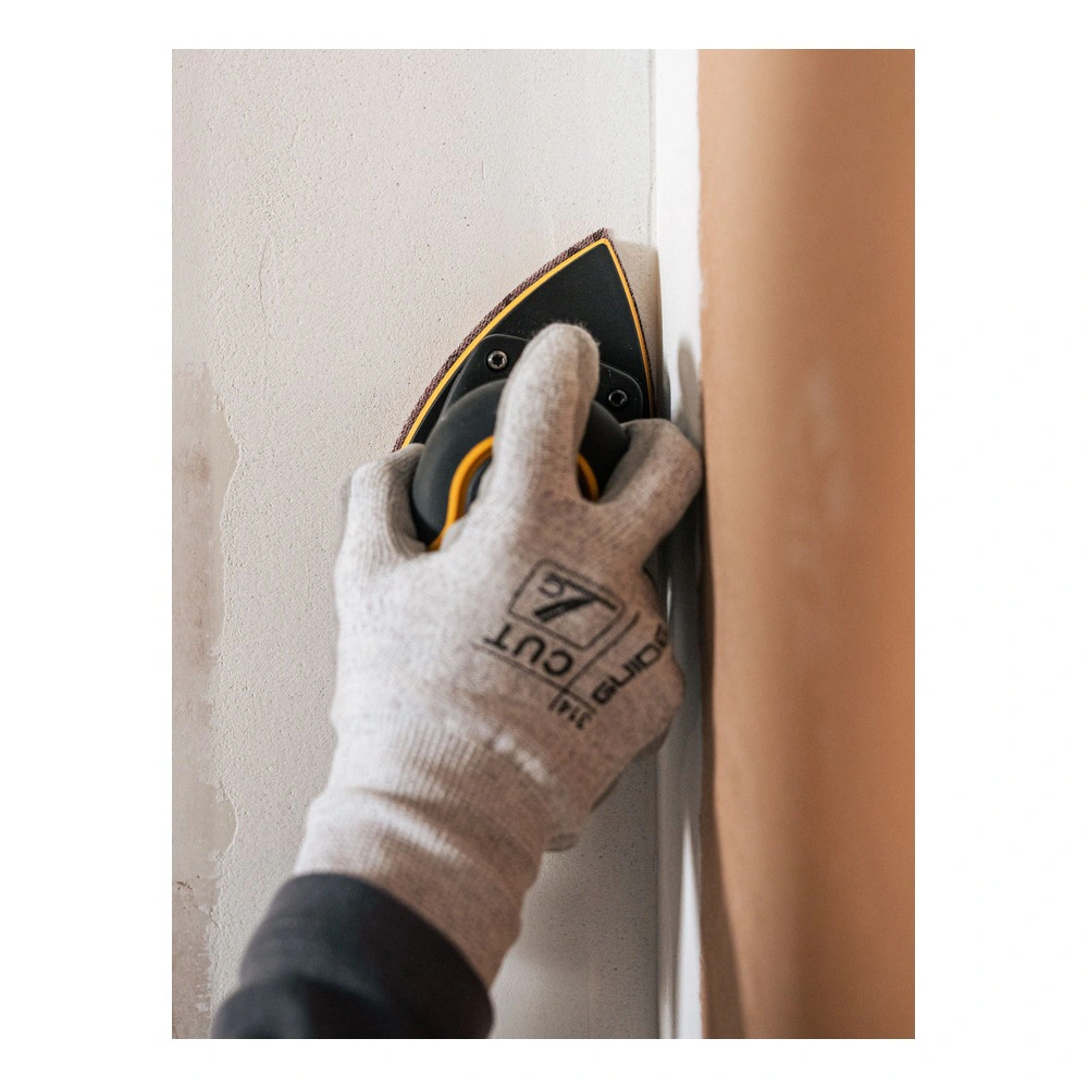 A gloved hand holds a yellow-and-black triangular sander in the corner