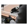 A person presses a sanding sheet onto a wooden surface using a tool, shown