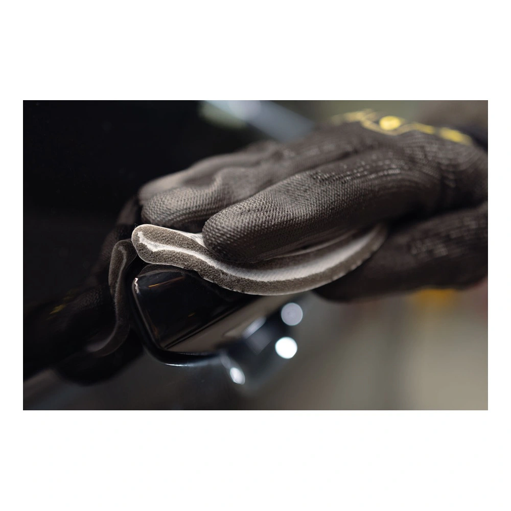 A close application photo of a gloved hand holding a dark curved surface