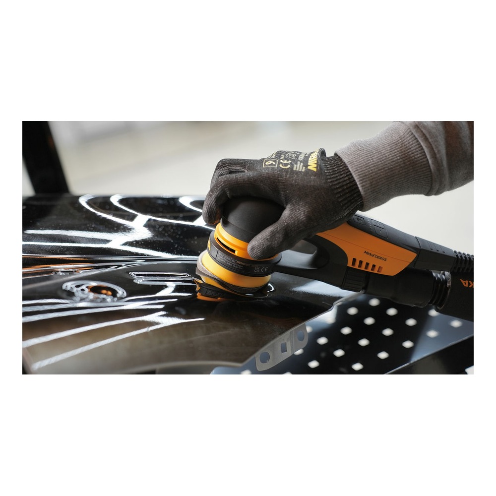 Person sanding a black surface with hand sander