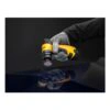 A gloved hand holds a yellow and black tool over a dark glossy surface