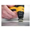 Yellow-and-black hand tool with a small round pad touching a glossy surface