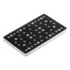 Black rectangular pad with a pattern of white holes and a thick white layer