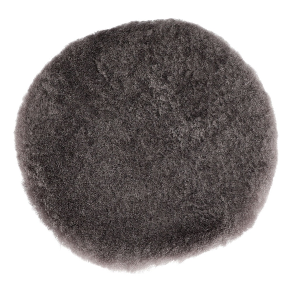 A round, dense gray-black wool pad shown in close-up on a white background