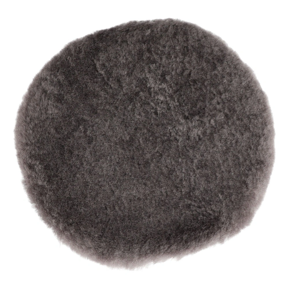 A round, dense gray-black wool pad shown in close-up on a white background