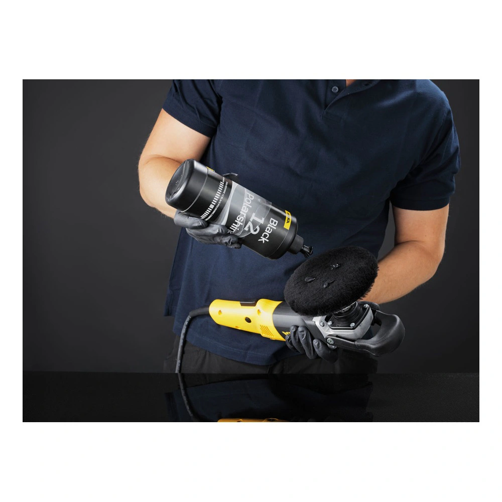 A person holding a polishing machine with a black lambswool pad, plus