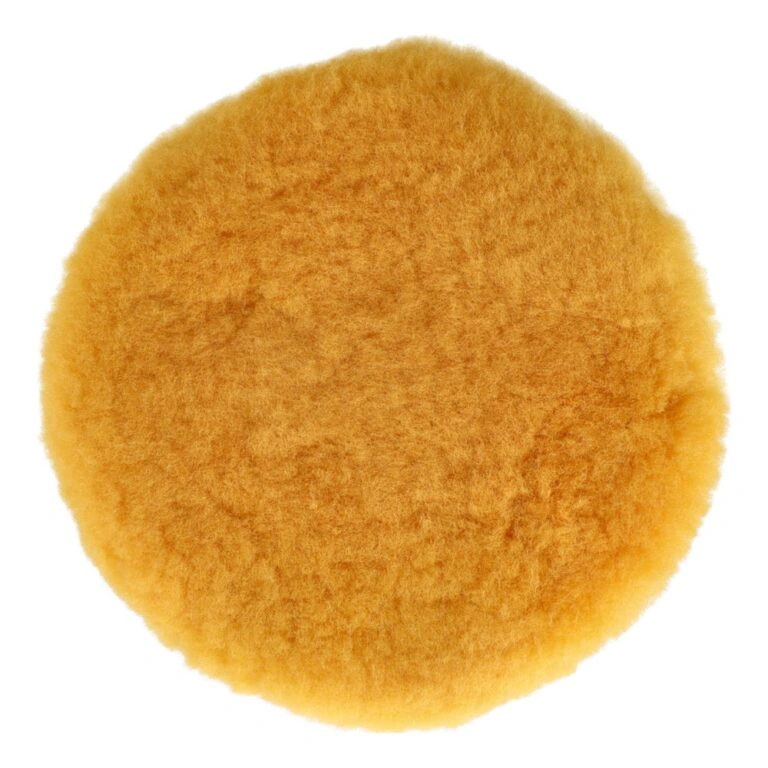 A fluffy round pad in yellow-orange, seen from above on a white background