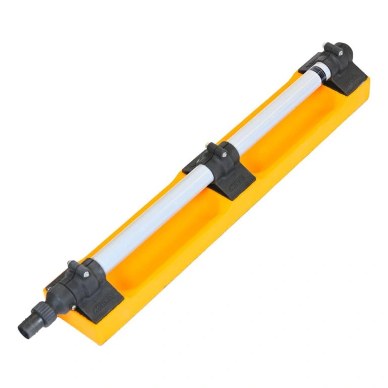 An angled top view of a yellow board with a white tube and two black clamps