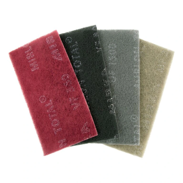 Four fibrous sanding pads in different colors