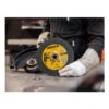 Worker holds grinding disc beside grinder