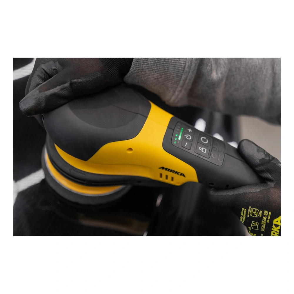 Black-yellow rotary polisher held in gloved hands