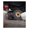 Technician holding cutting wheel beside grinder