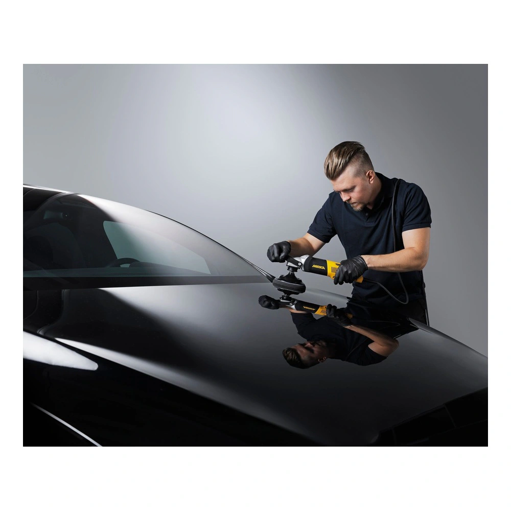 Man polishing a black car hood with machine