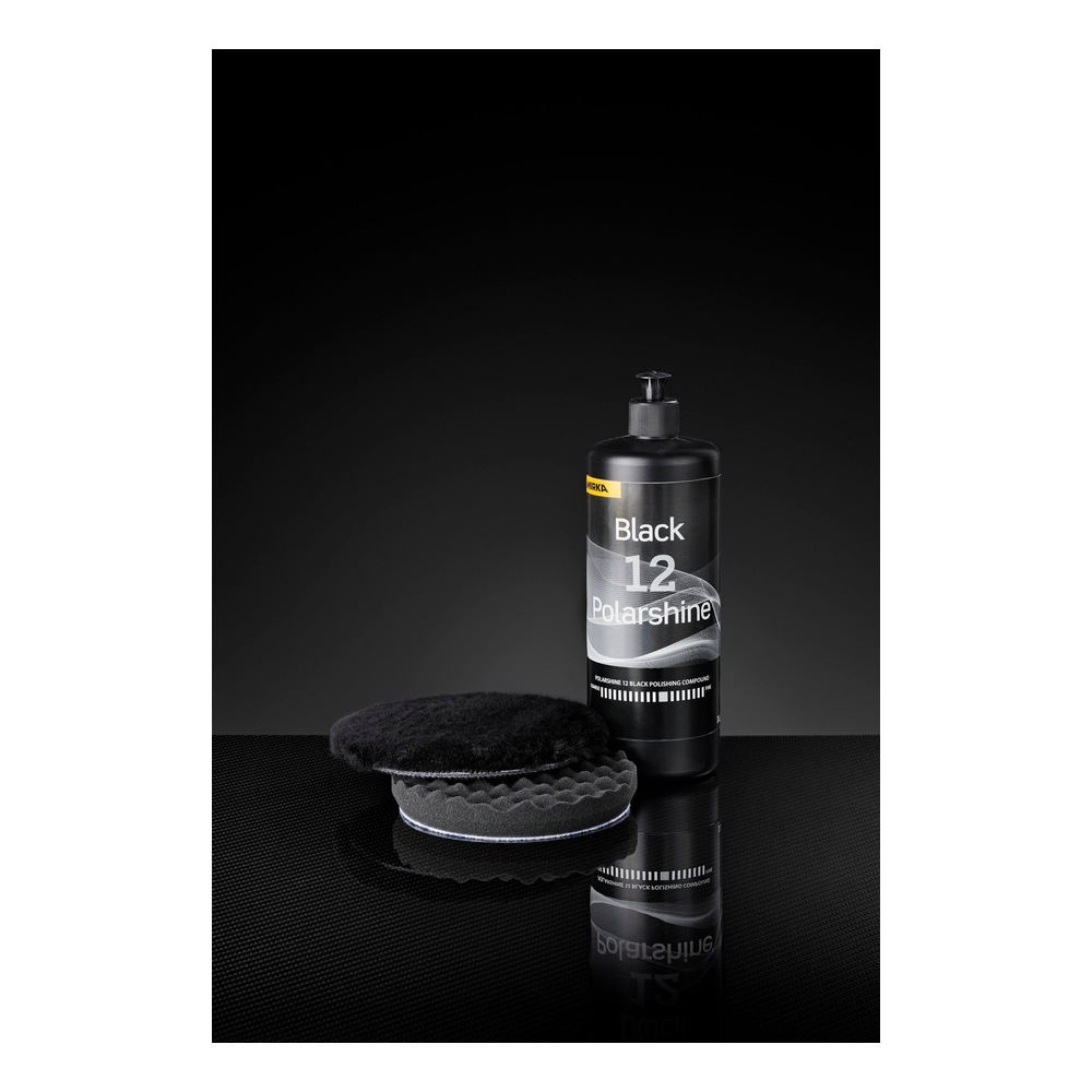 Black polish bottle with buffing pad, dark background